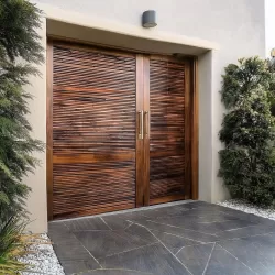 Firefly A modern, minimalist pivot door made of rich walnut wood. Horizontal slats with a subtle gra